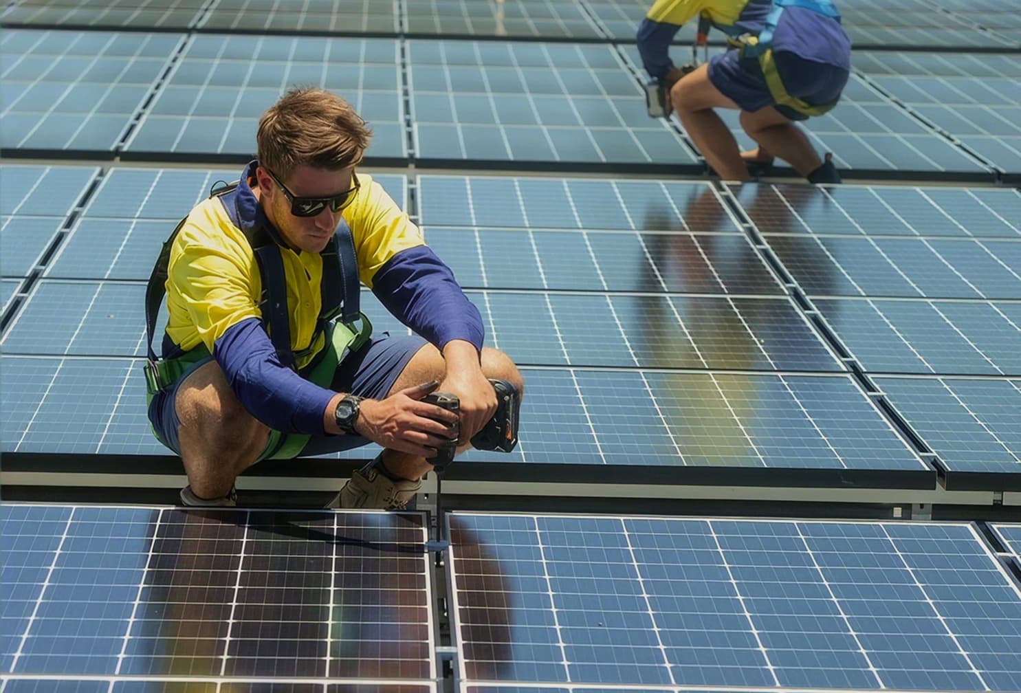 Electricians installing solar panels on a rooftop